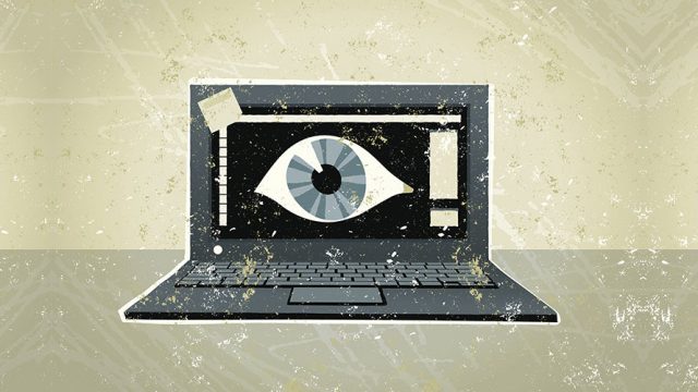 A black laptop computer; on the computer is a giant eyeball