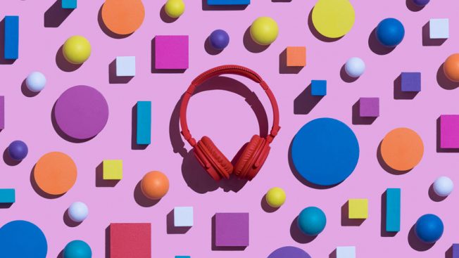 Pink background with colorful shapes and red headphones.