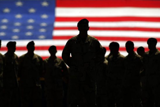 Silhouettes of Army members in front of American flag