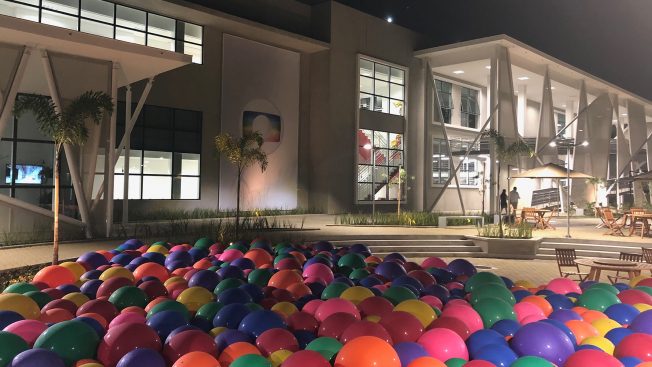 Multi-colored balloons filling a pool outside of a minimalistic mansion in Brazil hosted by Globo