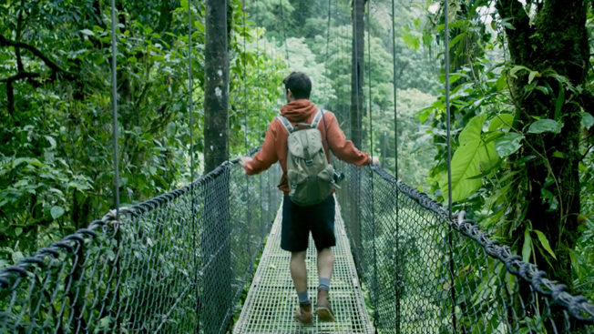 A hiker walks across a bridge in Costa Rica