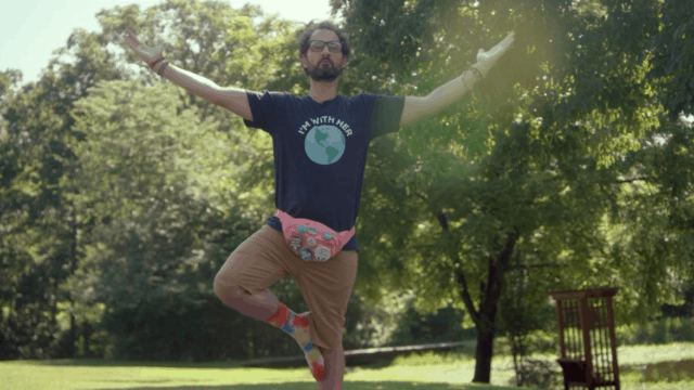 man doing a yoga pose in a park