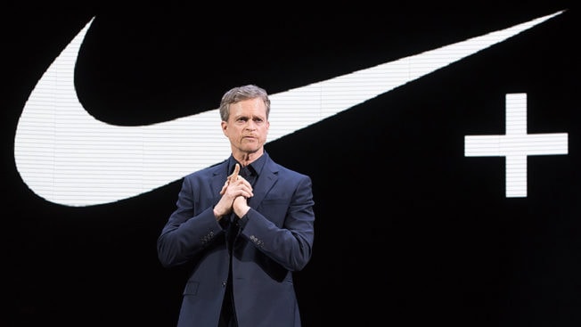 photo of man in front of Nike Just Do It checkmark logo