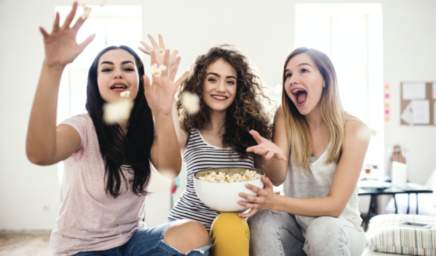 a group of girls eating and throwing popcorn