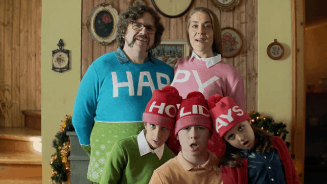 a family in christmas sweaters and hats singing
