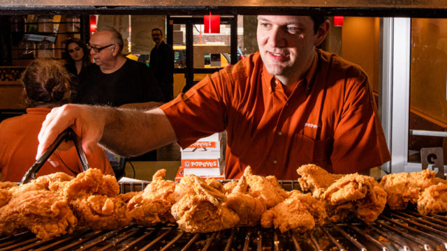 Popeyes' head of North American marketing, Bruno Cardinali, picking out a piece of chicken with tongs