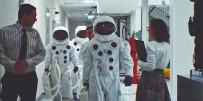 Astronauts walk toward the camera in footage that seems to date from the 1960s