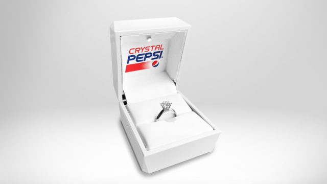 A ring box with a ring that says Crystal Pepsi on the top half of the box