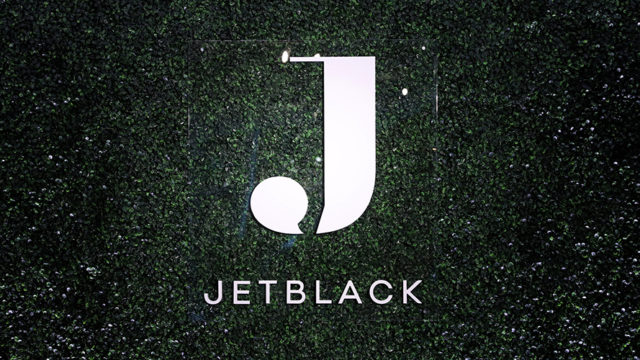 White Jetblack logo on greenish-black background