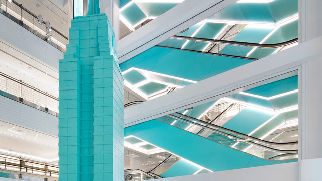 a turquoise skyscraper inside a lobby