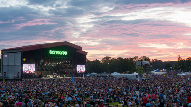 a concert at sunset with a crowded stage that says bonnaroo