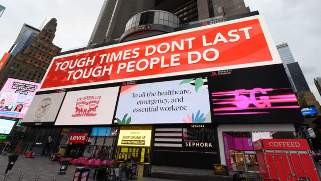 Photo of big billboard ads with one on top that says, 'Tough Times Don't Last Tough People Do'