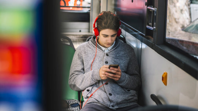 a guy with headphones on on a bus