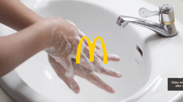 A photo of a person washing their hands in a sink with the McDonald's logo