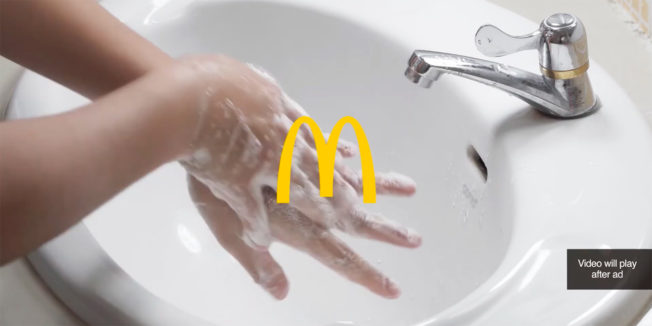 A photo of a person washing their hands in a sink with the McDonald's logo
