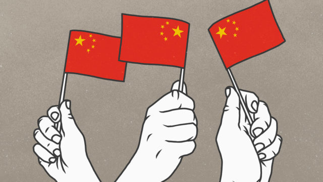 white hands holding small red flags with yellow stars in the corner (chinese flags)