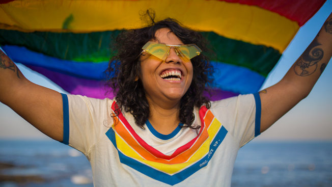 a woman holding a rainbow flag