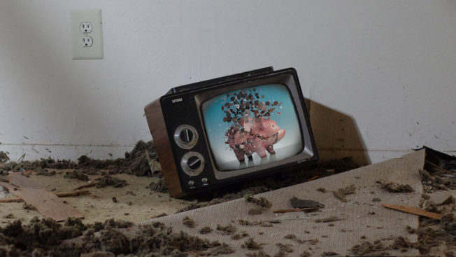 A TV on the floor with a smashed piggy bank on the screen
