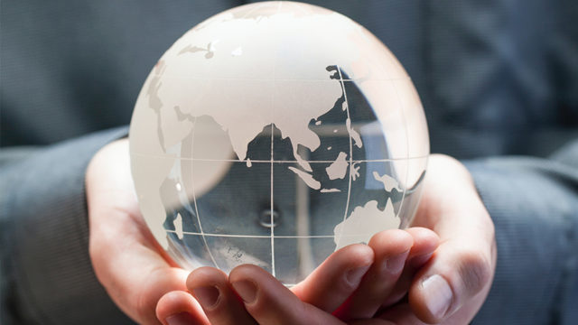 Person holding glass world globe in hands