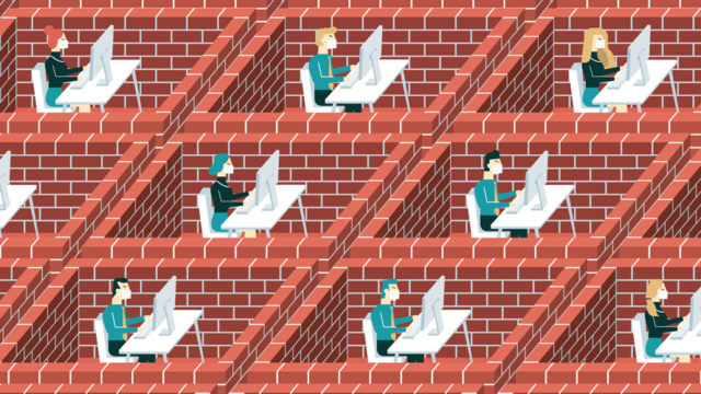 people sitting in bricked-in cubicles