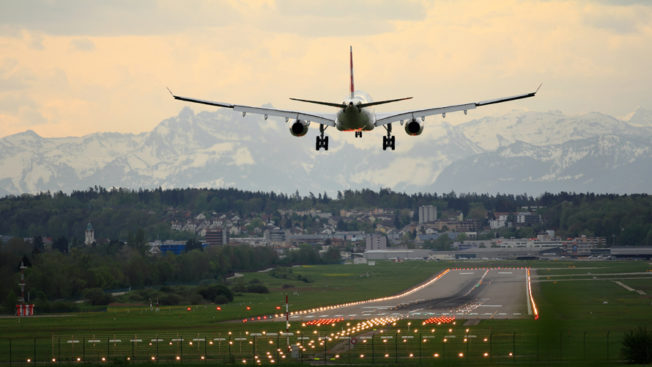 Airplane landing with mountains in the distance