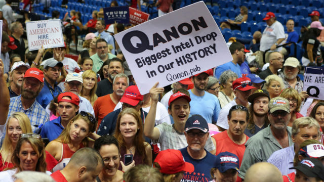 crowd with people holding QAnon signs