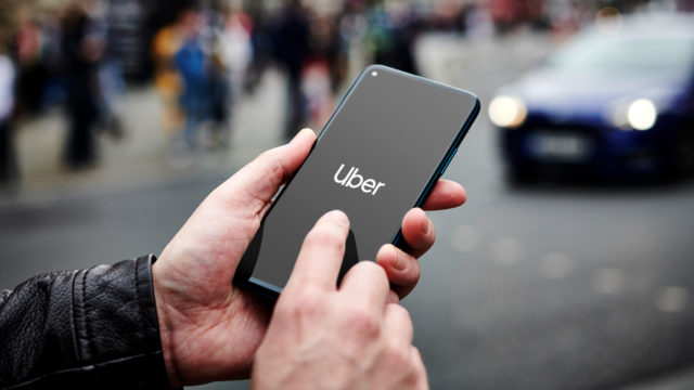 a person holding a phone that has the uber logo on it