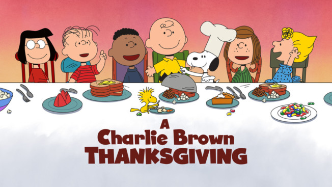 the peanuts gang sitting at a big thanksgiving table with the words: A Charlie Brown Thanksgiving underneath