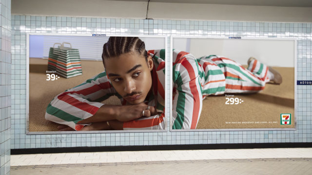 A male model lies on his stomach wearing 7-Eleven branded pajamas in an outdoor ad