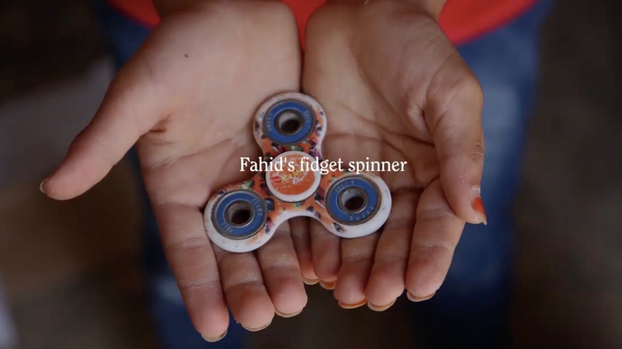 a kids hands with a fidget spinner in its open palms