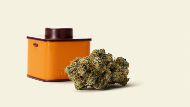 A tin of Houseplant brand cannabis is shown next to whole flower cannabis