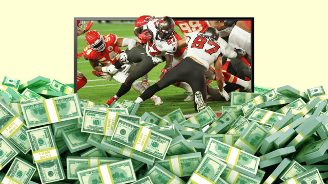 piles of cash on the floor and a flat-screen tv showing a game of football behind it