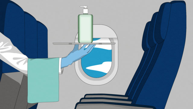 person holding a bottle of hand sanitizer on a plane