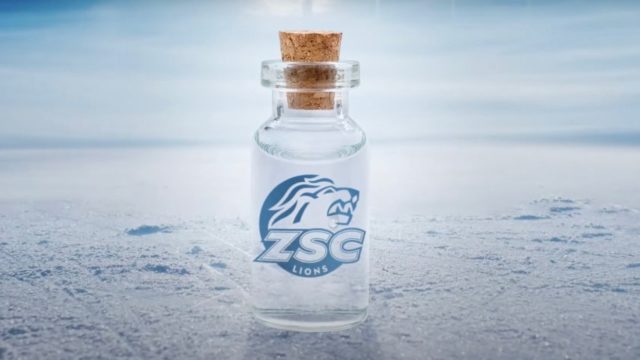 A clear bottle of water with a a cork stopper and a lion head logo sits on a sheet of ice