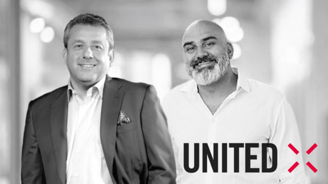 two men standing next to each other with united x logo in bottom right