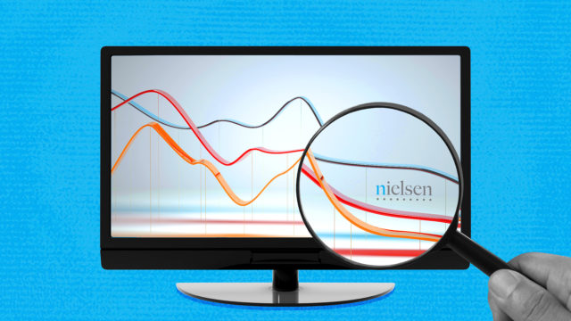 A computer screen with the Nielsen logo shows a graph with three lines trending downwar.d