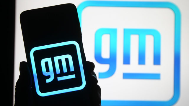 gm logo in background and gm logo on a shadowed phone screen