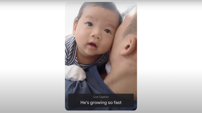 In a vertical phone screen, a baby looks into the camera over his father's shoulder during a Google Meet chat with a caption saying He's growing so fast