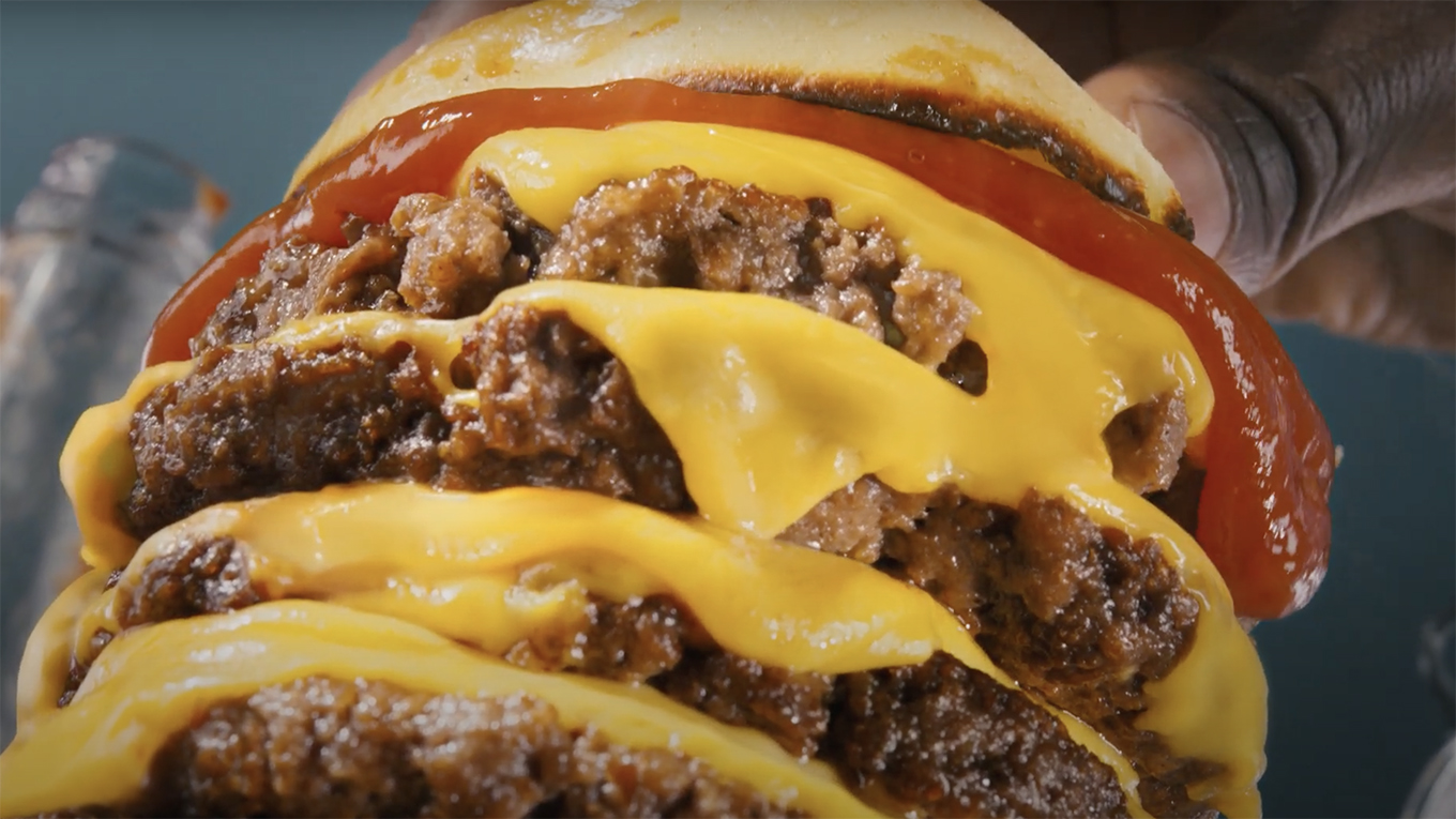 a close-up photo of a four-tiered cheeseburger
