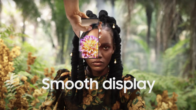 girl sitting in jungle with phone over her eye that has a flower on the screen with 