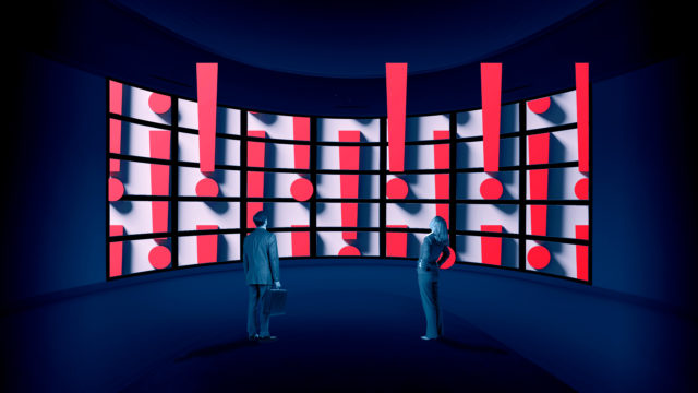 man and woman looking at a giant screen full of exclamation marks