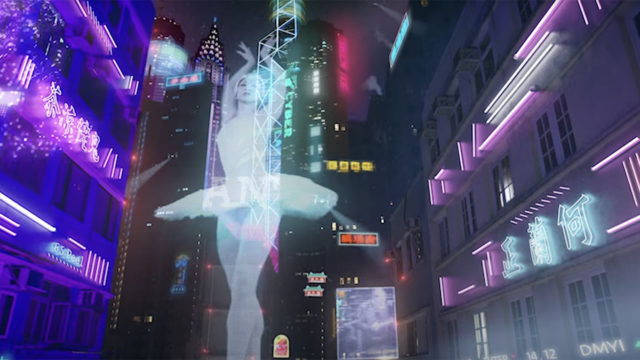 The image of a ballerina is projected across the side of a highrise in a futuristic cityscape