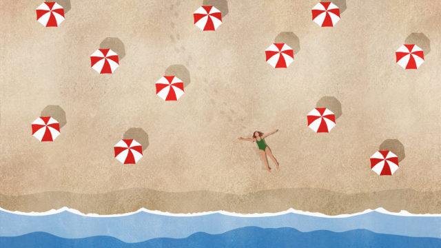 a person lying on a beach among red and white beach umbrellas