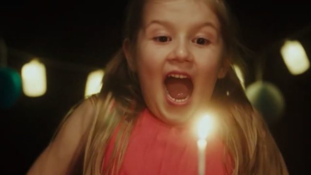 Girl blows out birthday candle