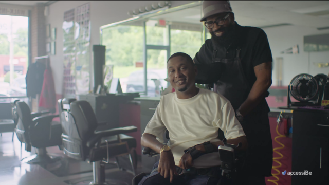 A man in a wheelchair sits in a barbershop