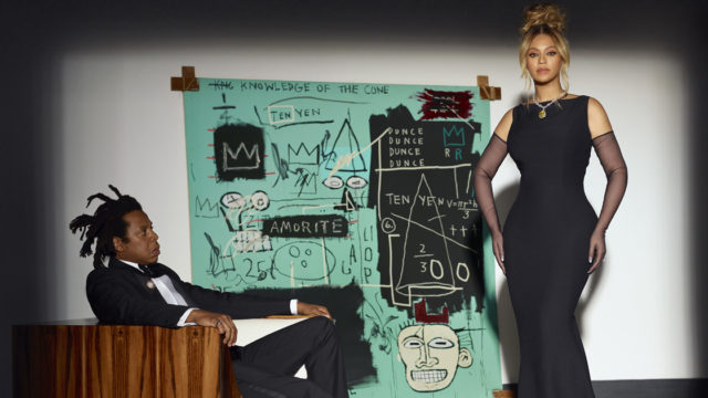 Photo of Beyonce and Jay-Z in black tie attire with Basquiat painting in the back in Tiffany's brand colors.