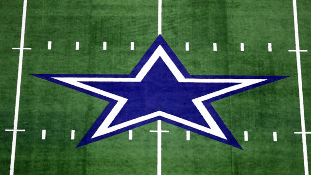 Dallas Cowboys blue and white star at 50 yard line of football field