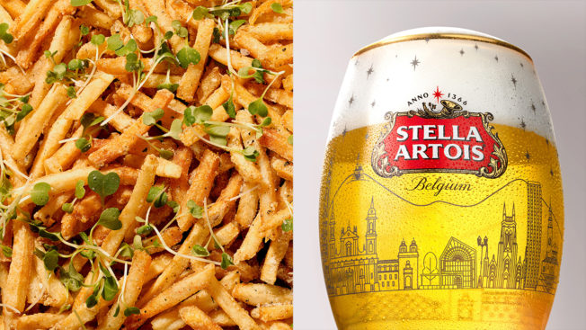 A tray of fries tossed with bean sprouts is shown net to a glass of Stella Artois