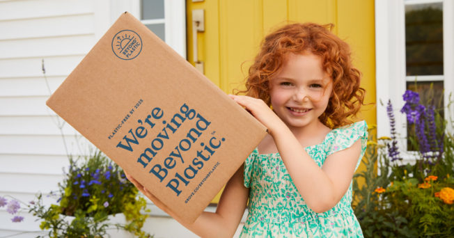 a little girl holding a cardboard box