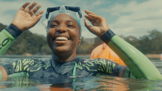 Woman in swimming cap smiling in the water